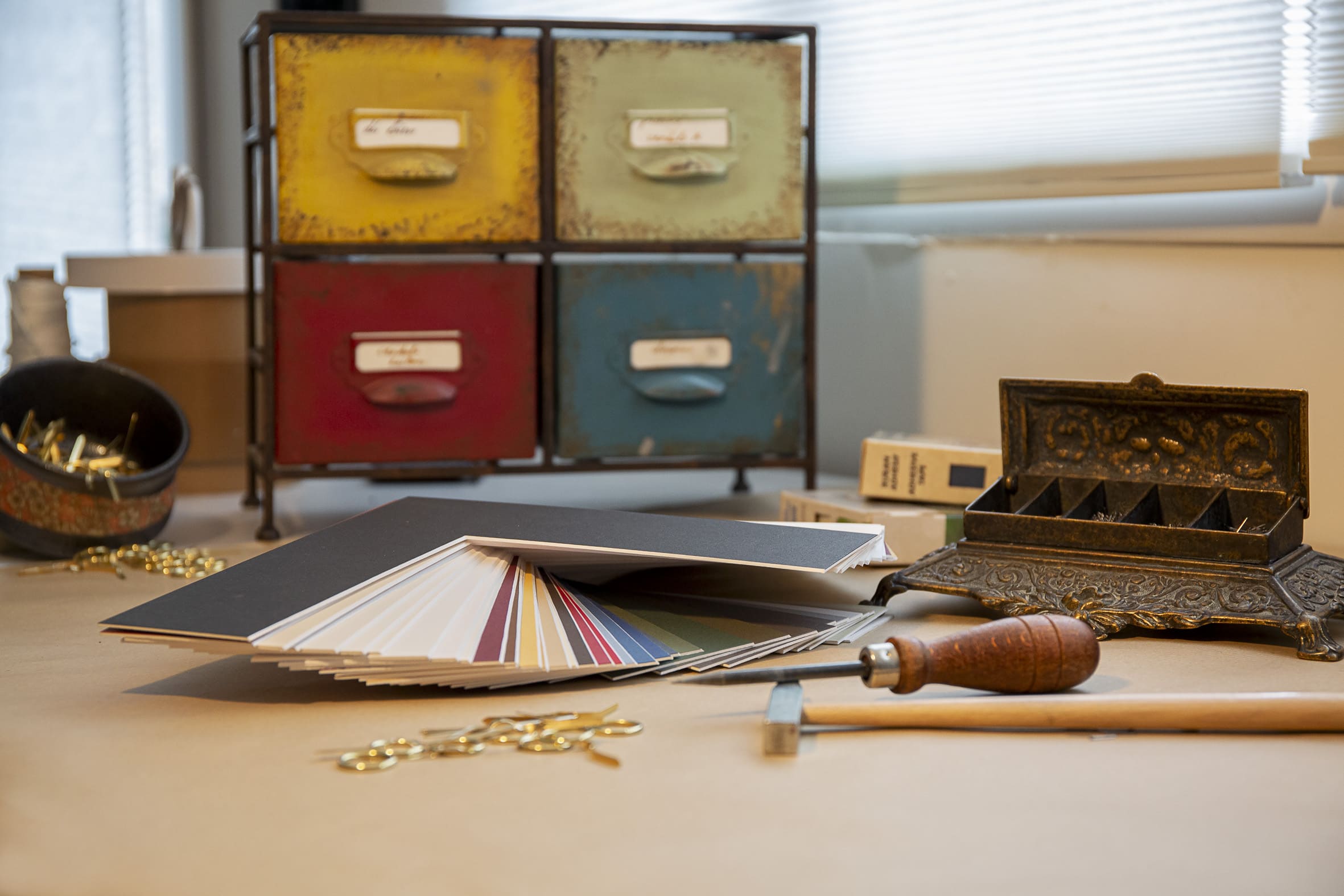 Photo d'un atelier d’encadrement. On y voit divers outils utiles à l'encadreur.